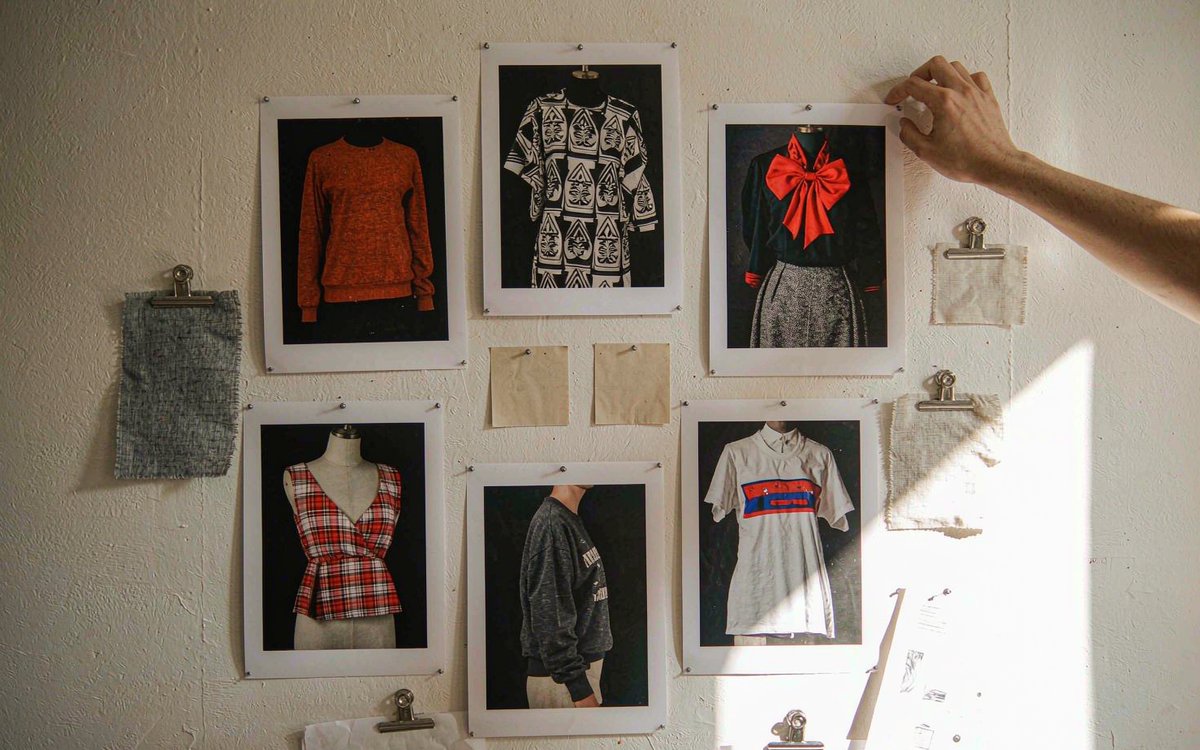 A printed moodboard with AI-generated fashion concept images pinned next to fabric swatches and handwritten notes