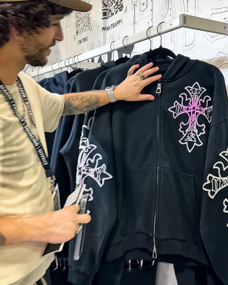 Buyer inspecting photochromic light-reactive hoodie at DOLUXE MAGIC Show booth