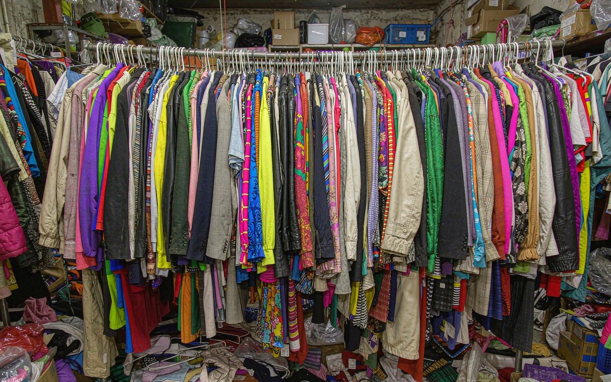 An overstuffed clothing rack with many different random garment styles crowded together